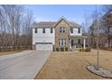 Inviting two-story home featuring mixed siding, well-manicured lawn, and attached two-car garage at 2233 Kanata Mills Rd, Wake Forest, NC 27587