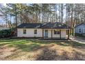Charming single-story home with a brick facade, blue door, and covered front porch at 2409 Keith Dr, Raleigh, NC 27610