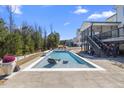 Inviting backyard oasis with a sparkling swimming pool, stylish lounge chairs, and patio area at 2632 Jordan Pointe Blvd, New Hill, NC 27562
