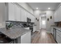 Modern kitchen with white cabinets, granite countertops, subway tile backsplash, and stainless steel appliances at 310 Chub Lake St, Roxboro, NC 27573