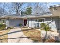 Charming single-story home featuring a brick pathway, manicured landscaping, and neutral toned siding at 32 Mt. Bolus Rd, Chapel Hill, NC 27514