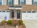 Charming townhome exterior with brick facade, two-car garage, and inviting front door adorned with a wreath at 368 Amber Acorn Ave, Raleigh, NC 27603