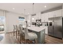 Bright kitchen featuring large island with bar stool seating, stainless appliances and wood flooring at 368 Amber Acorn Ave, Raleigh, NC 27603