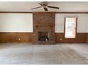 Spacious living room featuring a brick fireplace, carpet, and natural light from a window at 3901 Carson Dr, Sanford, NC 27332