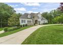 Elegant two-story home featuring stone accents, manicured landscaping, and a charming, winding driveway at 40 Park Meadow Ln, Youngsville, NC 27596