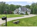 Charming two-story home with light blue siding, black shutters, well-manicured lawn, and a circular driveway at 40 Park Meadow Ln, Youngsville, NC 27596