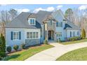 A luxurious two-story home with stone and siding, manicured landscaping, and a circular driveway at 40 Park Meadow Ln, Youngsville, NC 27596