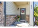 Inviting front porch featuring decorative wreath, stone accents, and a charming 'wipe your feet' doormat for a warm welcome at 420 Retreat Ln, Wake Forest, NC 27587