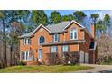 Traditional brick home featuring manicured lawn, attached garage and mature landscaping at 4225 Old Lewis Farm Rd, Raleigh, NC 27604