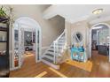 Inviting foyer with hardwood floors, staircase, and arched doorways, filled with natural light at 4225 Old Lewis Farm Rd, Raleigh, NC 27604