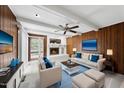 Inviting living room with wood paneling, a cozy fireplace, modern furniture and a ceiling fan at 4905 Will-O-Dean Rd, Raleigh, NC 27616