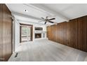 Bright living room featuring a white brick fireplace, wood paneling, a ceiling fan and outdoor access at 4905 Will-O-Dean Rd, Raleigh, NC 27616