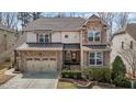 Inviting two-story home featuring stone accents, a two-car garage, and meticulously landscaped front yard at 5012 Trembath Ln, Cary, NC 27519