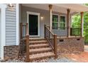 Covered front porch featuring sturdy wooden support columns and brick base with black metal railing at 5507 Eagles Nest Trl, Snow Camp, NC 27349