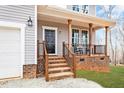 The welcoming front porch has wooden columns, decorative railings, and rocking chairs at 5507 Eagles Nest Trl, Snow Camp, NC 27349