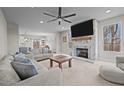 Open-concept living room featuring a fireplace, ceiling fan, and views into the kitchen and dining area at 5507 Eagles Nest Trl, Snow Camp, NC 27349