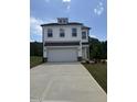 Two story home with white siding, a two-car garage, and a well-maintained lawn at 553 Winding Creek Dr, Lillington, NC 27546