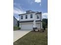 Beautiful two-story home with white siding, a two-car garage, and a lovely landscaped yard at 553 Winding Creek Dr, Lillington, NC 27546