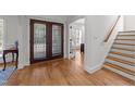 Welcoming foyer showcasing hardwood floors, staircase, and french doors leading to an adjacent room at 5714 Belmont Valley Ct, Raleigh, NC 27612