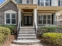 Inviting front entrance featuring stone steps, elegant columns, and a well-manicured landscape at 5714 Belmont Valley Ct, Raleigh, NC 27612