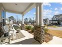 Relaxing front porch view with comfortable seating and decorative stone pillars overlooking the neighborhood at 63 Capewood Ct, Garner, NC 27529