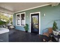 Inviting covered porch with a swing, seating, and a classic black front door at 632 E Franklin St, Raleigh, NC 27604