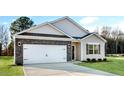 A cozy home with a two-car garage, highlighted by a combination of siding and brick accents at 71 Hawksmoore Ln, Lillington, NC 27546