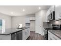 Modern kitchen featuring white cabinets, stainless steel appliances, and a large island with granite countertops at 71 Hawksmoore Ln, Lillington, NC 27546