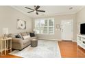 Inviting living room features hardwood floors, a cozy sofa, and natural light from large windows at 7810 Spungold St, Raleigh, NC 27617