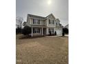 Inviting two-story home showcasing a neatly manicured lawn, a welcoming front porch, and a two-car garage at 82 Cool Creek Dr, Willow Springs, NC 27592