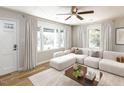 Bright living room featuring a stylish couch, large windows and a ceiling fan at 823 Elmira Ave, Durham, NC 27707