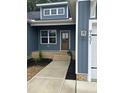 Inviting entryway with a brown front door, brick steps, fresh landscaping, and modern exterior lighting at 9231 Bear Run Ln, Middlesex, NC 27557