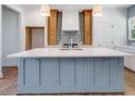 Stunning kitchen island with a white countertop and stylish blue cabinetry with stainless hardware at 9231 Bear Run Ln, Middlesex, NC 27557