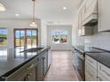 Well-lit kitchen with a gray kitchen island, stainless steel appliances, and adjacent dining area at 9235 Bear Run Ln, Middlesex, NC 27557