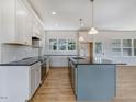 Bright kitchen featuring white cabinets, a central island, and stainless steel appliances at 9235 Bear Run Ln, Middlesex, NC 27557