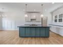 Bright kitchen featuring a large island, stainless steel appliances, and modern pendant lighting at 9235 Bear Run Ln, Middlesex, NC 27557