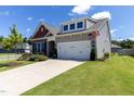 Attractive home with a two-car garage, green lawn, and colorful flowerbeds at 1 Parker Pond Ct, Durham, NC 27703