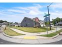 A neighborhood corner view showcasing a gray home, manicured lawns and sidewalks at 1 Parker Pond Ct, Durham, NC 27703