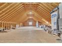 The unfinished attic, with its exposed beams, presents a versatile space for future expansion or custom renovation at 10 Holden Ct, Youngsville, NC 27596