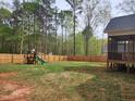 Spacious backyard with a wooden fence and a play set, ideal for outdoor activities and Gathering fun at 105 Shawnee Drive, Louisburg, NC 27549