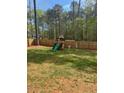 A backyard featuring a wooden playset with a slide and swings, perfect for entertainment at 105 Shawnee Drive, Louisburg, NC 27549
