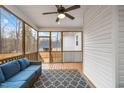 Cozy screened porch with comfortable seating and a ceiling fan, perfect for relaxing outdoors at 105 Shawnee Drive, Louisburg, NC 27549