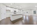 Open-concept kitchen with a white island, stainless steel appliances, pendant lighting, and modern cabinetry, offering a seamless flow at 1103 Freestone Rd, Durham, NC 27703
