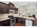 Well-appointed kitchen with modern appliances, granite countertops and sleek dark cabinets at 114 Mt Evans Dr, Durham, NC 27705