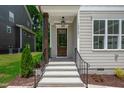 Inviting entryway with a glass paneled wooden door, black railings, and concrete steps at 12912 Grey Willow Dr, Raleigh, NC 27613