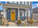 A cozy front porch with a bright yellow door, decorative columns, and a small seating area at 173 E Wilson St, Clayton, NC 27520