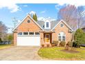 Charming one-story brick home with attached garage, manicured lawn, and inviting entryway at 2 Poplar Ave, Elon, NC 27244