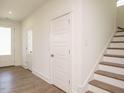Bright entryway featuring wood-look floors, white trim, and a staircase to the upper level at 267 Parkland Dr Dr, Pittsboro, NC 27312