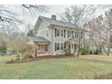 Classic home featuring a covered porch, manicured lawn, and mature trees at 301 Hillsborough St, Chapel Hill, NC 27514