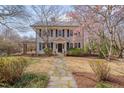 Inviting two-story home with stone walkway, lush landscaping, and blooming trees at 301 Hillsborough St, Chapel Hill, NC 27514